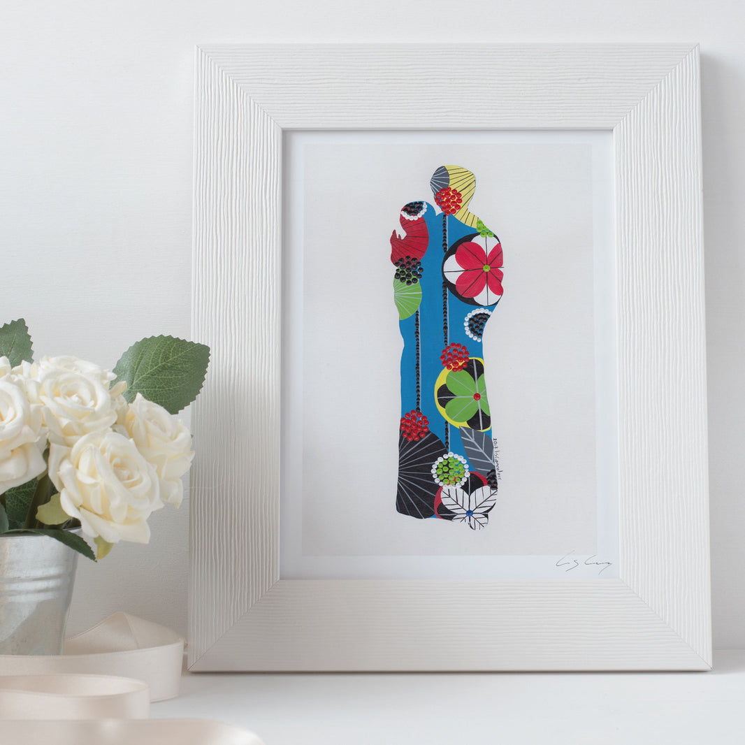 A framed fine art print, by Lis Gonçalves. Open edition, signed by the artist (printed in Hahnemühle matt fibre paper) featuring a colorful Saint Anthony on a white surface with flowers.