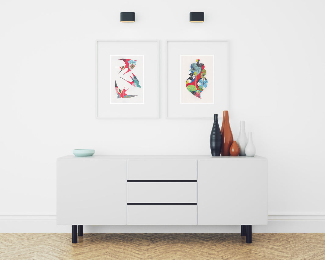 Two framed fine art prints, by Lis Gonçalves. Open edition, signed by the artist (printed in Hahnemühle matt fibre paper) featuring colorful swallows and a Portuguese heart on a white sideboard with decorative vases on a white wall.