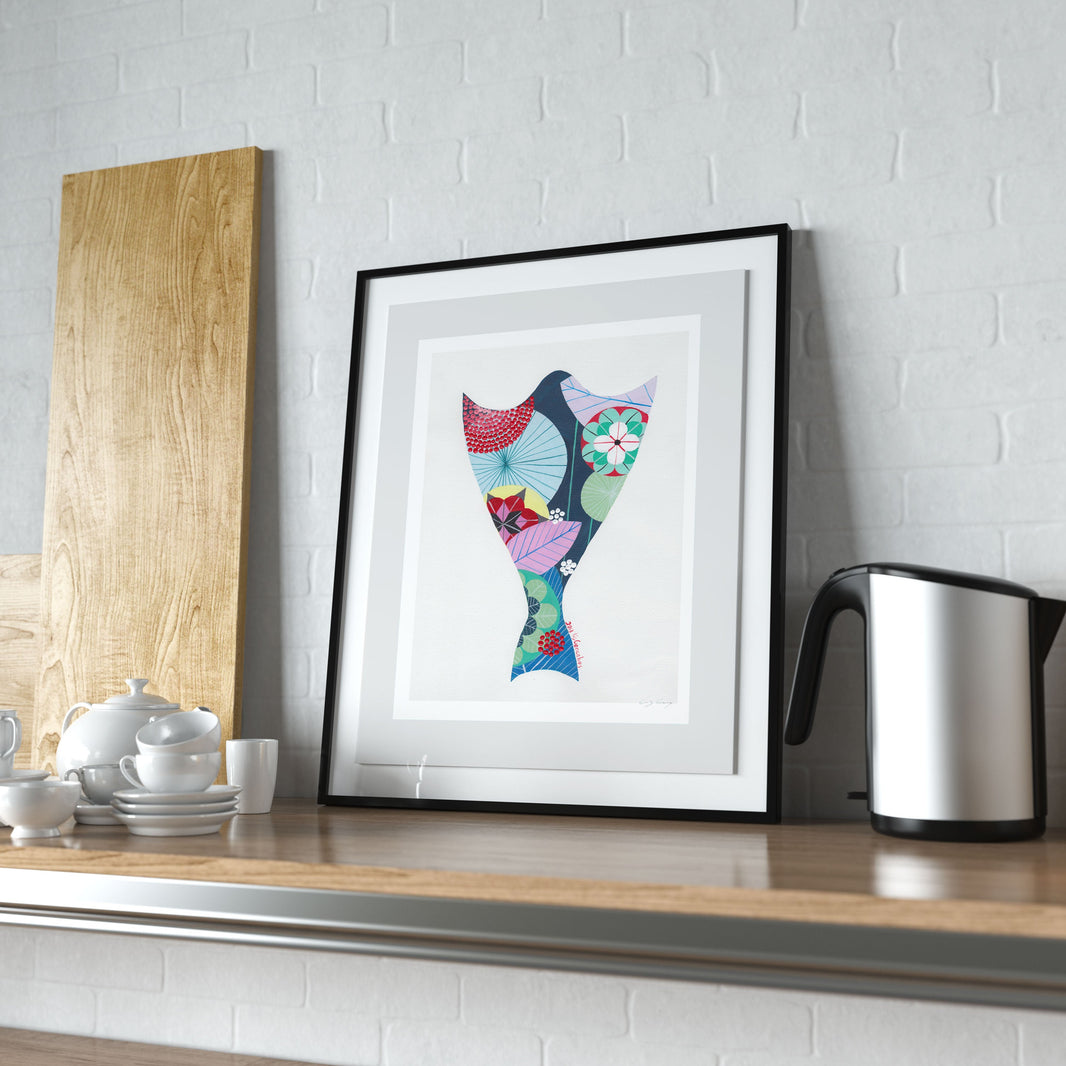 A framed fine art print, by Lis Gonçalves. Open edition, signed by the artist (printed in Hahnemühle matt fibre paper) featuring a colorful cod fish illustration on a wooden shelf with kitchen items