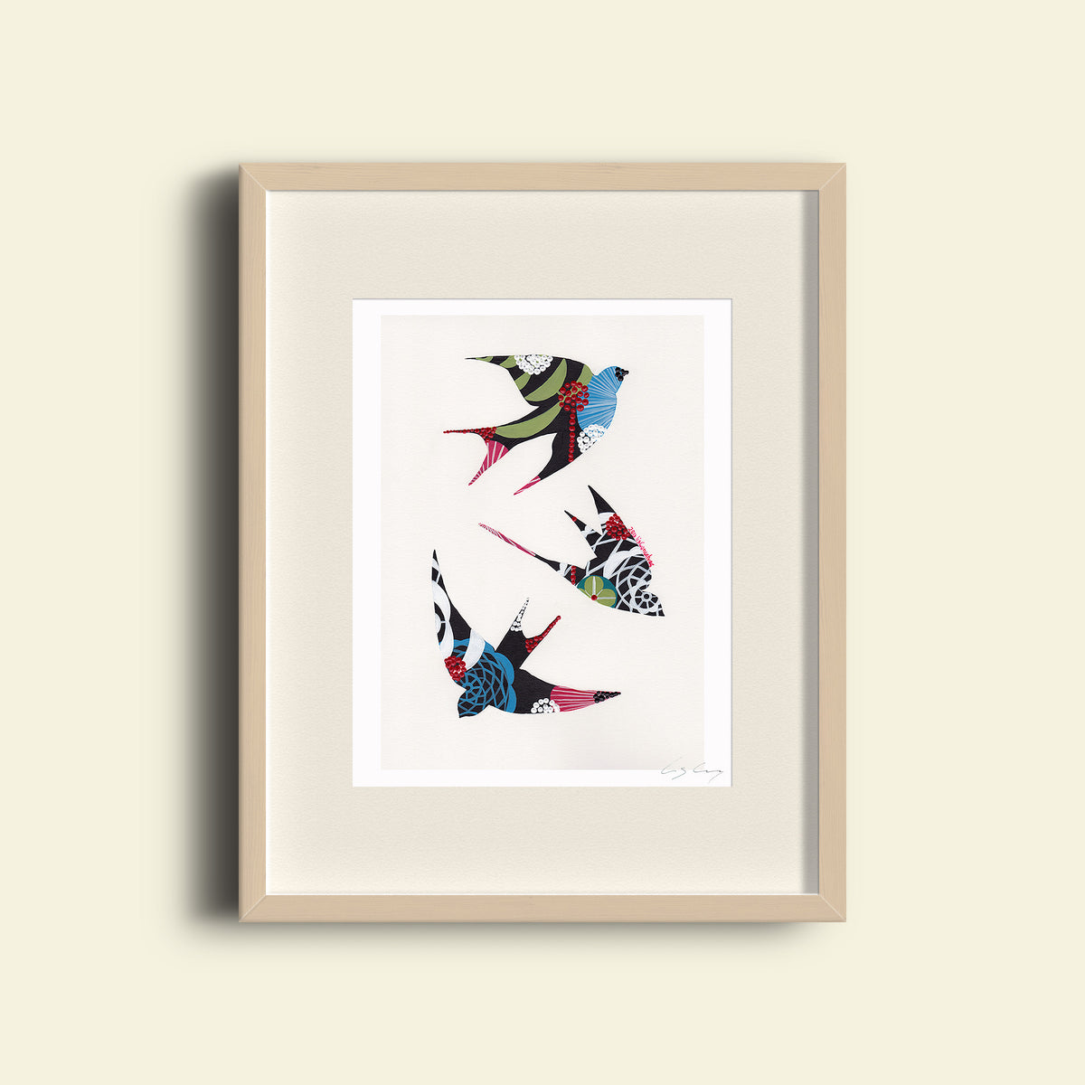 A framed fine art print, by Lis Gonçalves. Open edition, signed by the artist (printed in Hahnemühle matt fibre paper) featuring a colorful swallows illustration on a beige wall