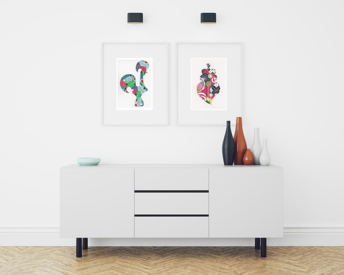 Two framed fine art prints, by Lis Gonçalves. Open edition, signed by the artist (printed in Hahnemühle matt fibre paper) featuring a colorful Portuguese Viana heart and a Portuguese Rooster in a modern living room with white sideboard and decorative vases.