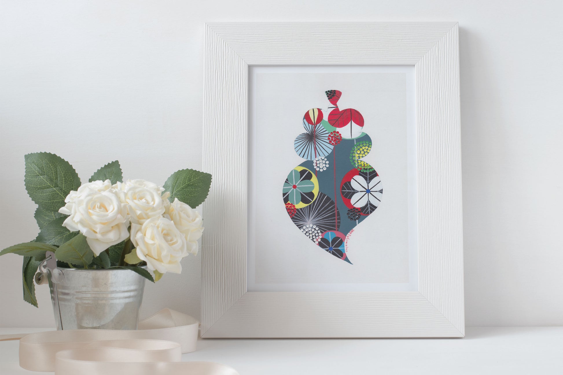 A framed fine art print, by Lis Gonçalves. Open edition, signed by the artist (printed in Hahnemühle matt fibre paper) featuring a colorful Portuguese Viana heart on a white surface with flowers and candles.