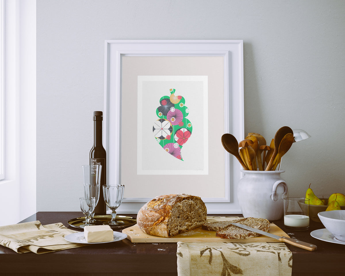 A framed fine art print, by Lis Gonçalves. Open edition, signed by the artist (printed in Hahnemühle matt fibre paper) featuring a colorful Portuguese Viana heart on a table setting with bread and wine.