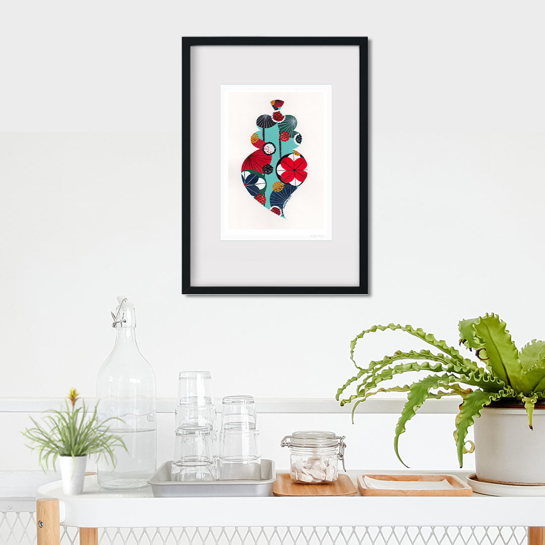 A framed fine art print, by Lis Gonçalves. Open edition, signed by the artist (printed in Hahnemühle matt fibre paper) featuring a colorful Portuguese Viana heart on a wall with plants and decor below