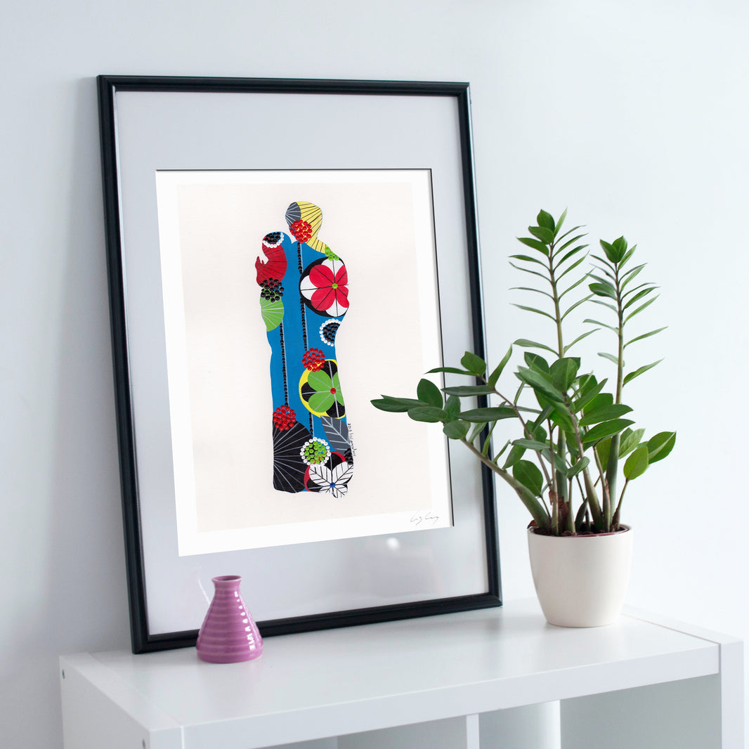 A framed fine art print, by Lis Gonçalves. Open edition, signed by the artist (printed in Hahnemühle matt fibre paper) featuring a colorful Saint Anthony on a white surface with a plant and small vase.