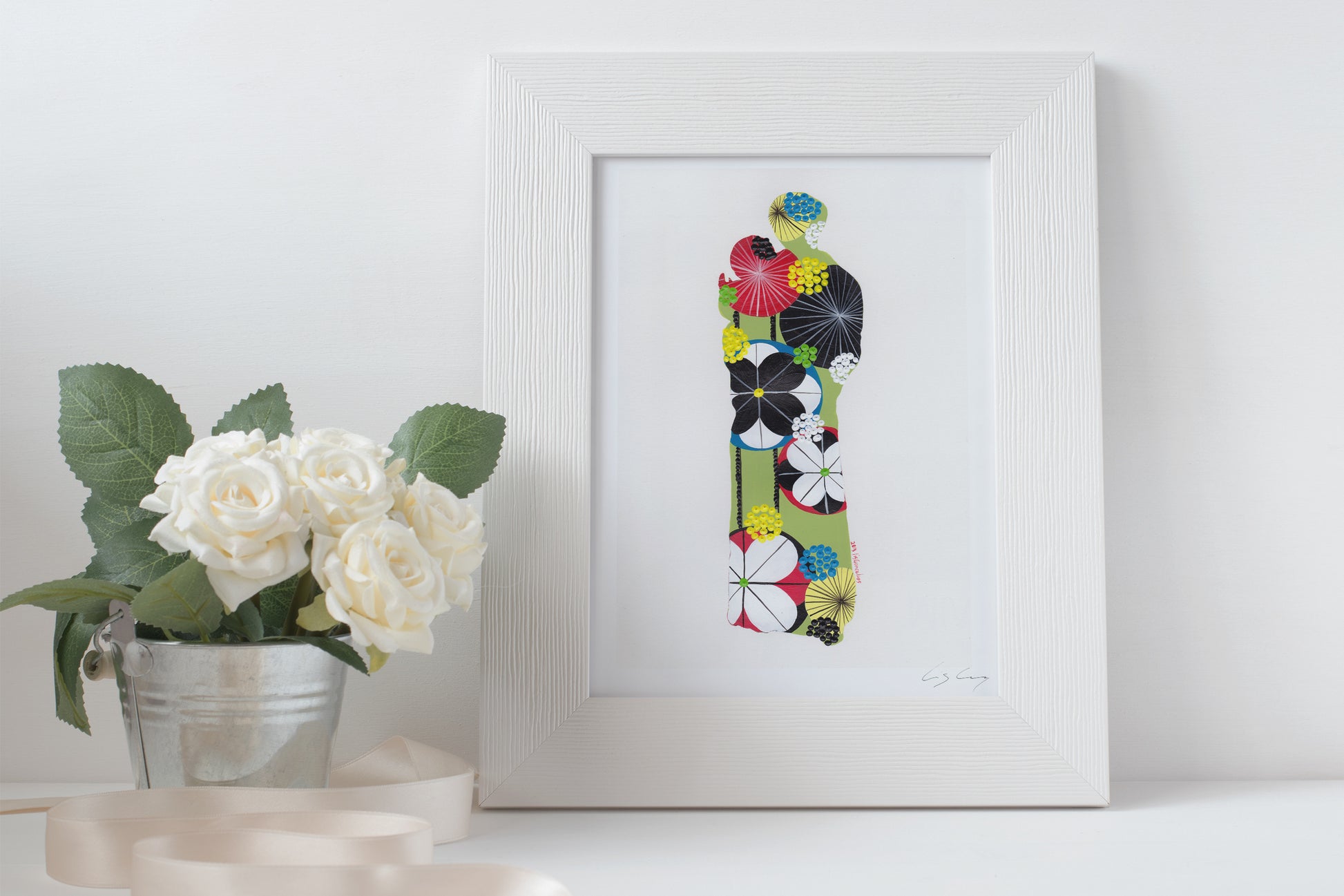 A framed fine art print, by Lis Gonçalves. Open edition, signed by the artist (printed in Hahnemühle matt fibre paper) featuring Saint Anthony on a white surface with a potted plant.