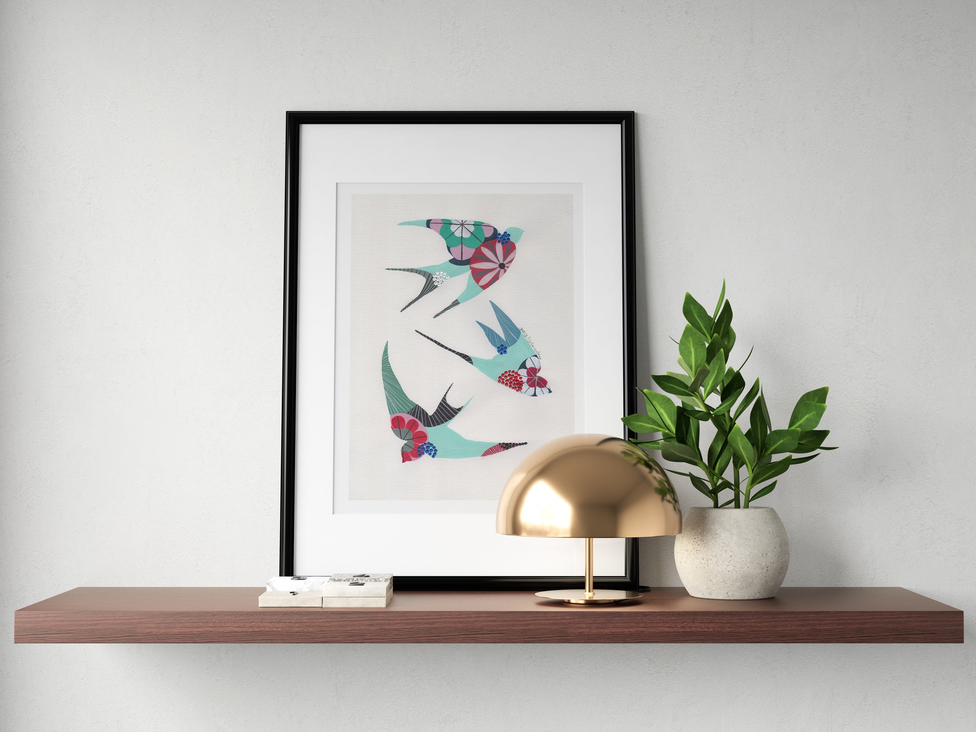 A framed fine art print, by Lis Gonçalves. Open edition, signed by the artist (printed in Hahnemühle matt fibre paper) featuring colorful swallows on a wooden shelf with a lamp and plant against a white wall