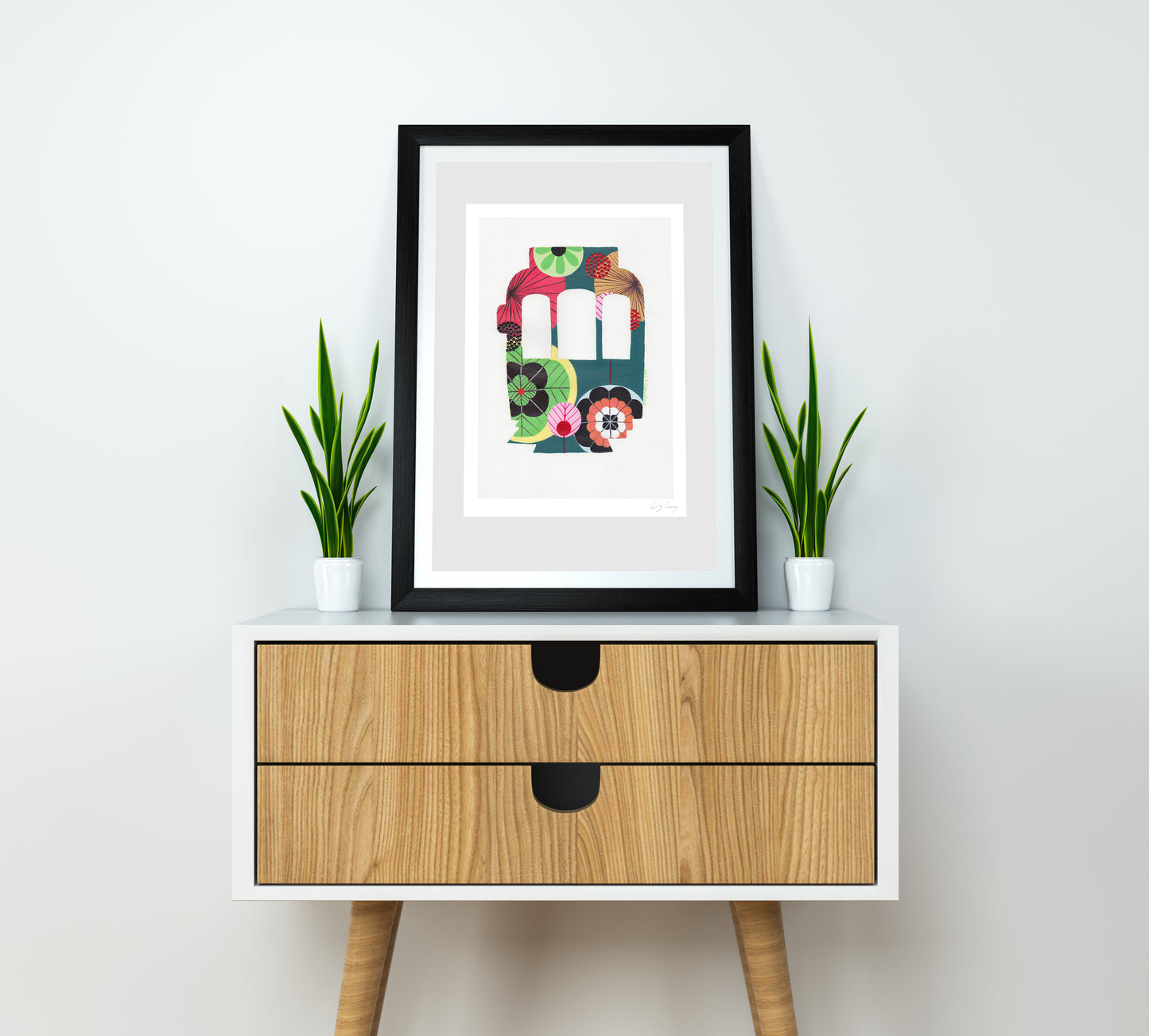 A framed fine art print, by Lis Gonçalves. Open edition, signed by the artist (printed in Hahnemühle matt fibre paper) featuring a colorful Lisbon tram on a wooden side table with plants against a white wall