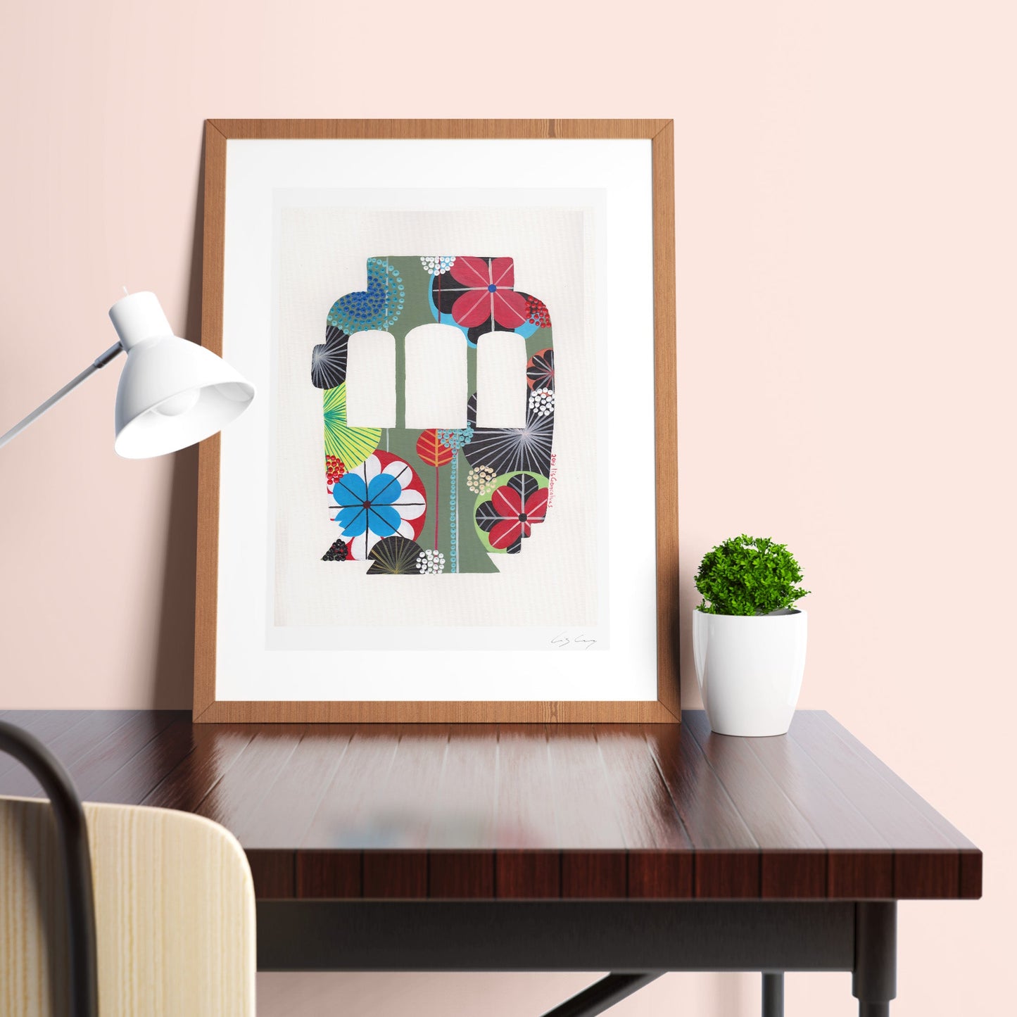 A framed fine art print, by Lis Gonçalves. Open edition, signed by the artist (printed in Hahnemühle matt fibre paper) featuring a colorful Lisbon tram on a desk with a lamp and plant.