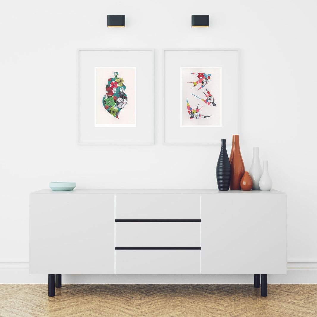 Two framed fine art prints, by Lis Gonçalves. Open edition, signed by the artist (printed in Hahnemühle matt fibre paper) featuring a colorful Portuguese Viana heart and swallows in a modern interior with a white cabinet and decorative vases.