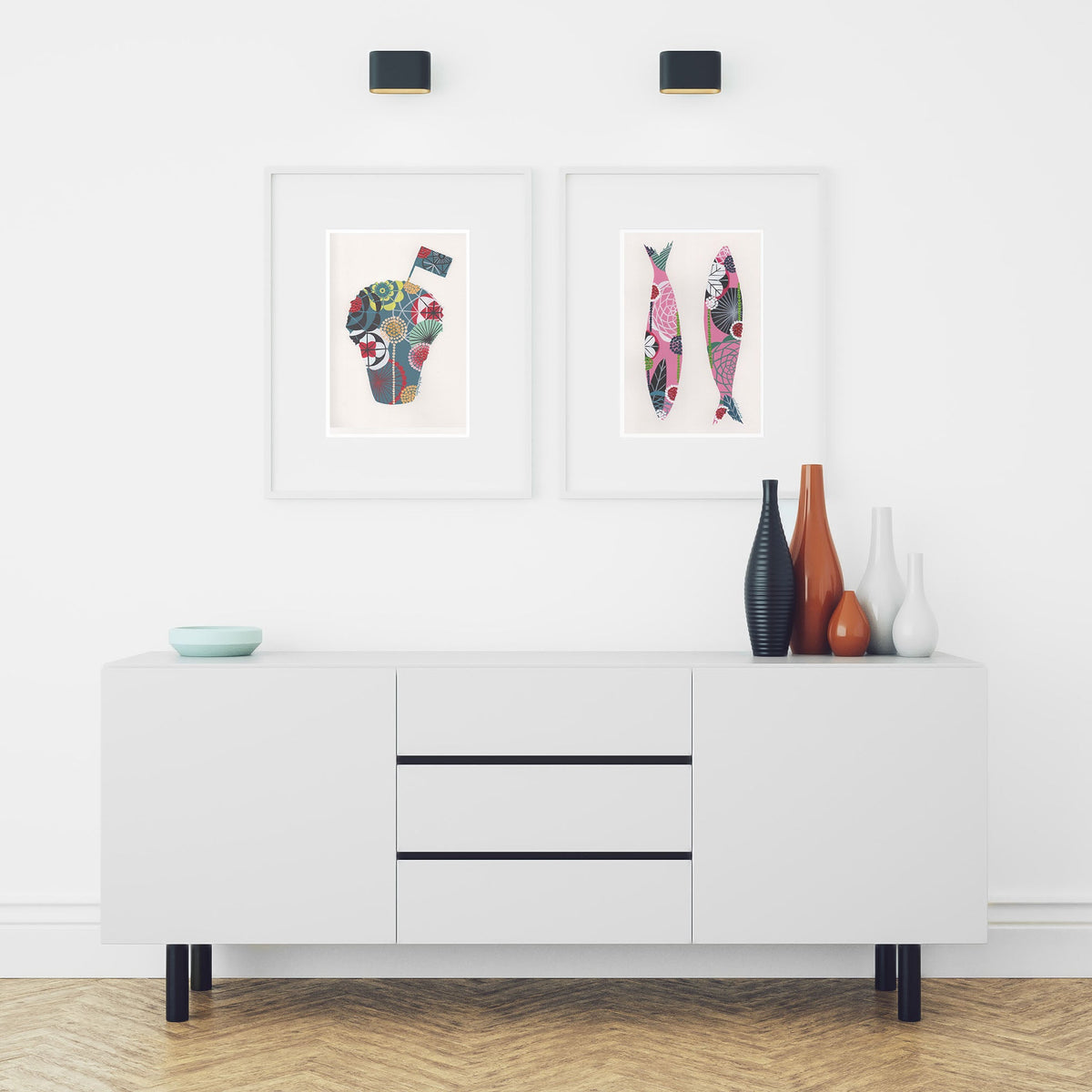 Two framed fine art prints, by Lis Gonçalves. Open edition, signed by the artist (printed in Hahnemühle matt fibre paper) featuring a manjerico and sardines, over a white cabinet with decorative items.