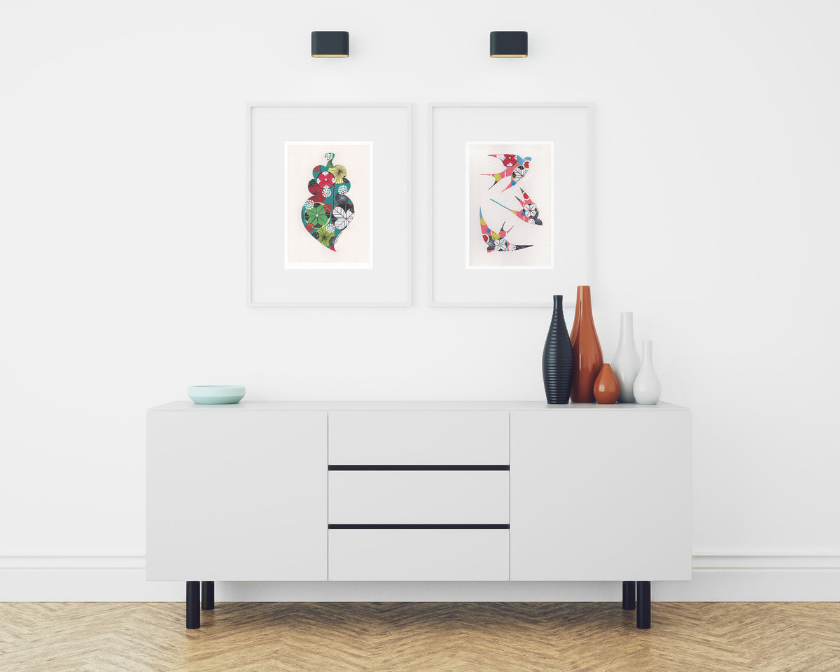 Two framed fine art prints, by Lis Gonçalves. Open edition, signed by the artist (printed in Hahnemühle matt fibre paper) featuring colorful swallows and a Portuguese heart in a modern interior with a white cabinet and decorative vases.