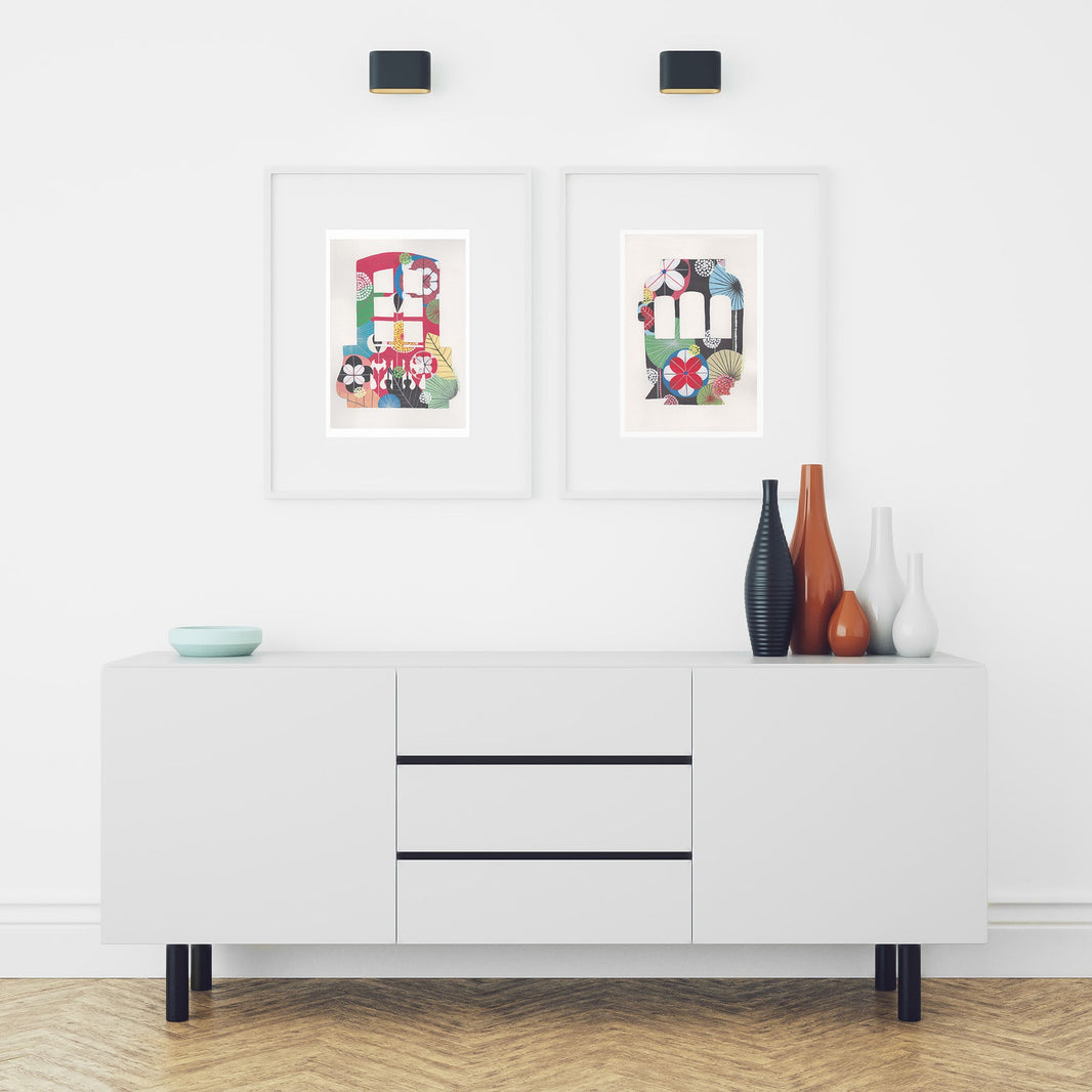 Two framed fine art prints, by Lis Gonçalves. Open edition, signed by the artist. Printed in Hahnemühle matt fibre paper; featured here are a Lisbon Balcony and Lisbon tram, framed, over a white console with decorative items.