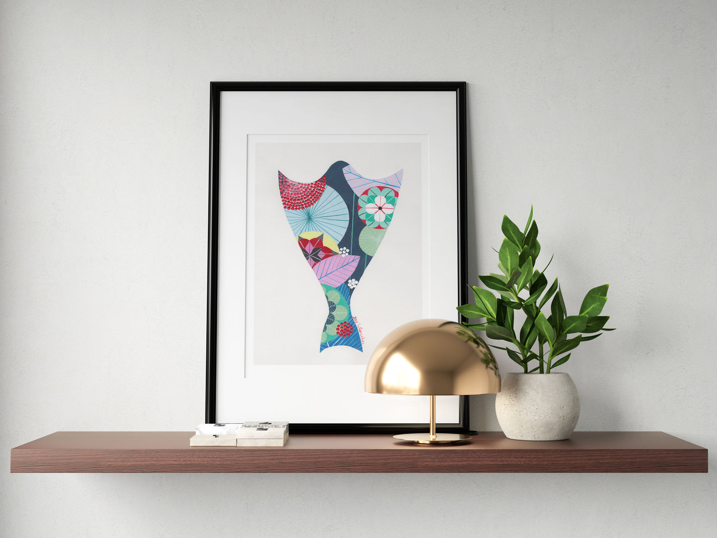 A framed fine art print, by Lis Gonçalves. Open edition, signed by the artist (printed in Hahnemühle matt fibre paper) featuring a colorful bacalhau on a wooden shelf with a gold lamp and plant against a white wall.