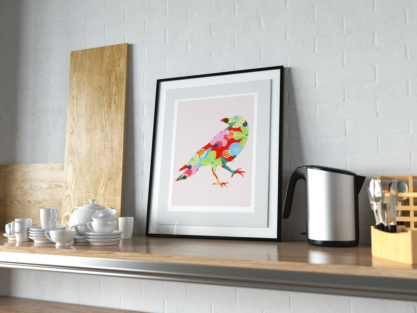 A framed fine art print, by Lis Gonçalves. Open edition, signed by the artist (printed in Hahnemühle matt fibre paper) featuring a colorful raven on a kitchen shelf with utensils and appliances.