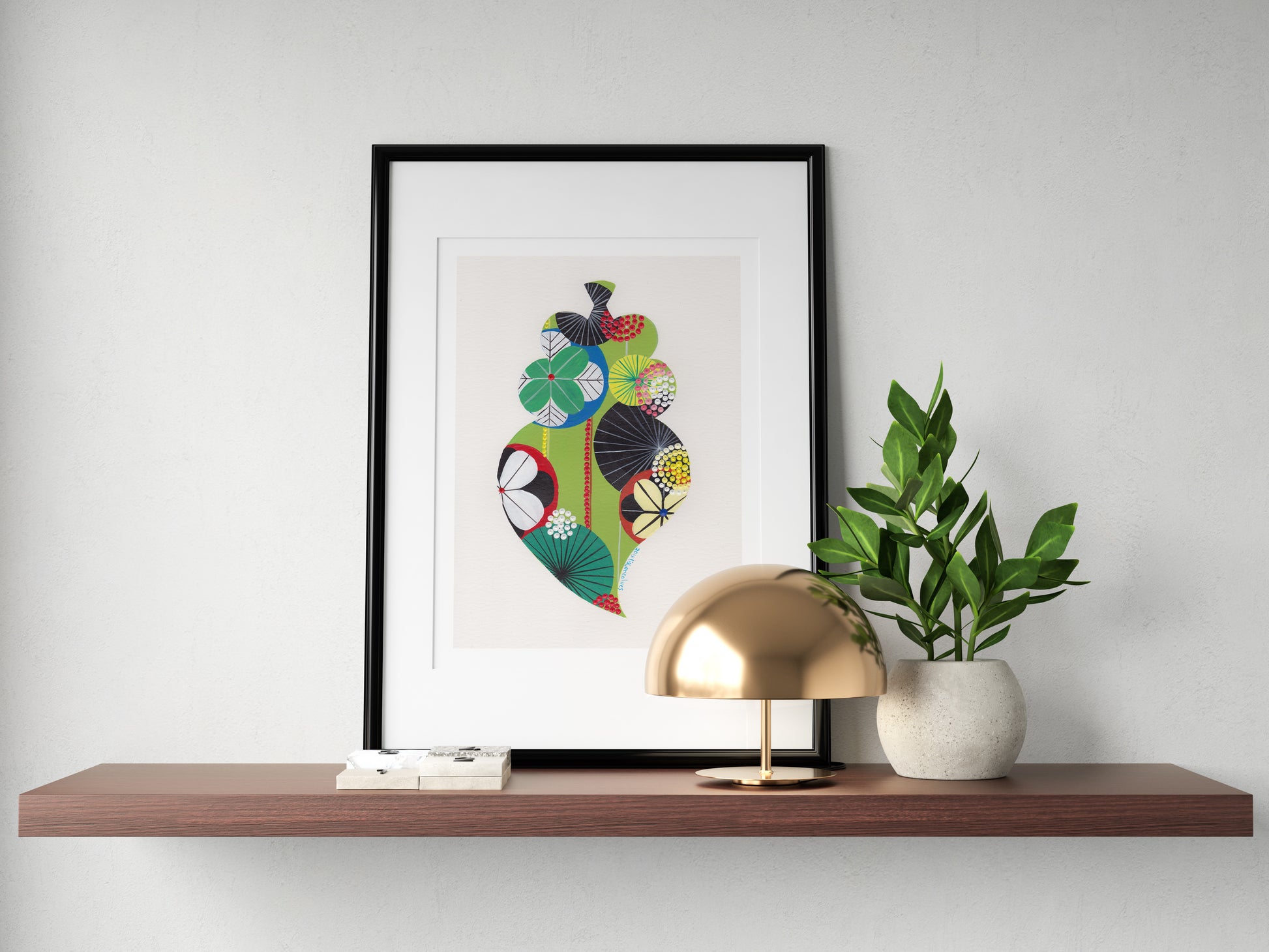 A framed fine art print, by Lis Gonçalves. Open edition, signed by the artist (printed in Hahnemühle matt fibre paper) featuring a colorful Portuguese Viana heart on a wooden shelf with a gold lamp and plant against a white wall.