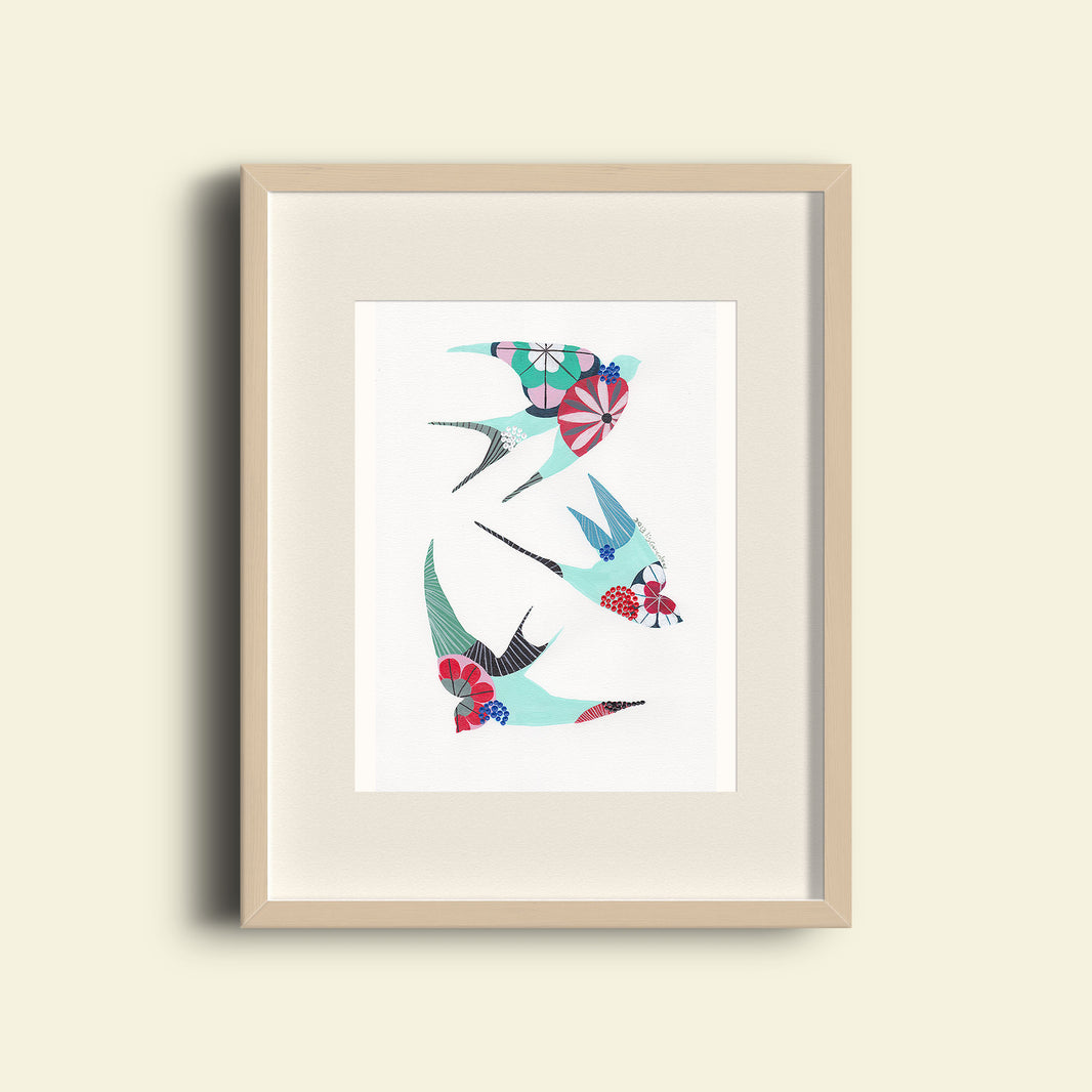 A framed fine art print, by Lis Gonçalves. Open edition, signed by the artist (printed in Hahnemühle matt fibre paper) featuring colorful swallows on a white background