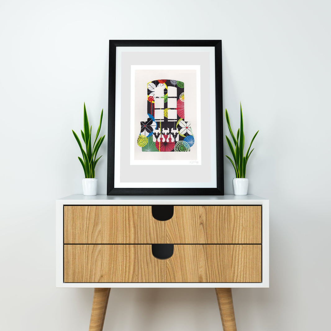 A framed fine art print, by Lis Gonçalves. Open edition, signed by the artist (printed in Hahnemühle matt fibre paper) featuring a colorful Lisbon balcony illustration on a white table with two potted green plants against a light gray wall.