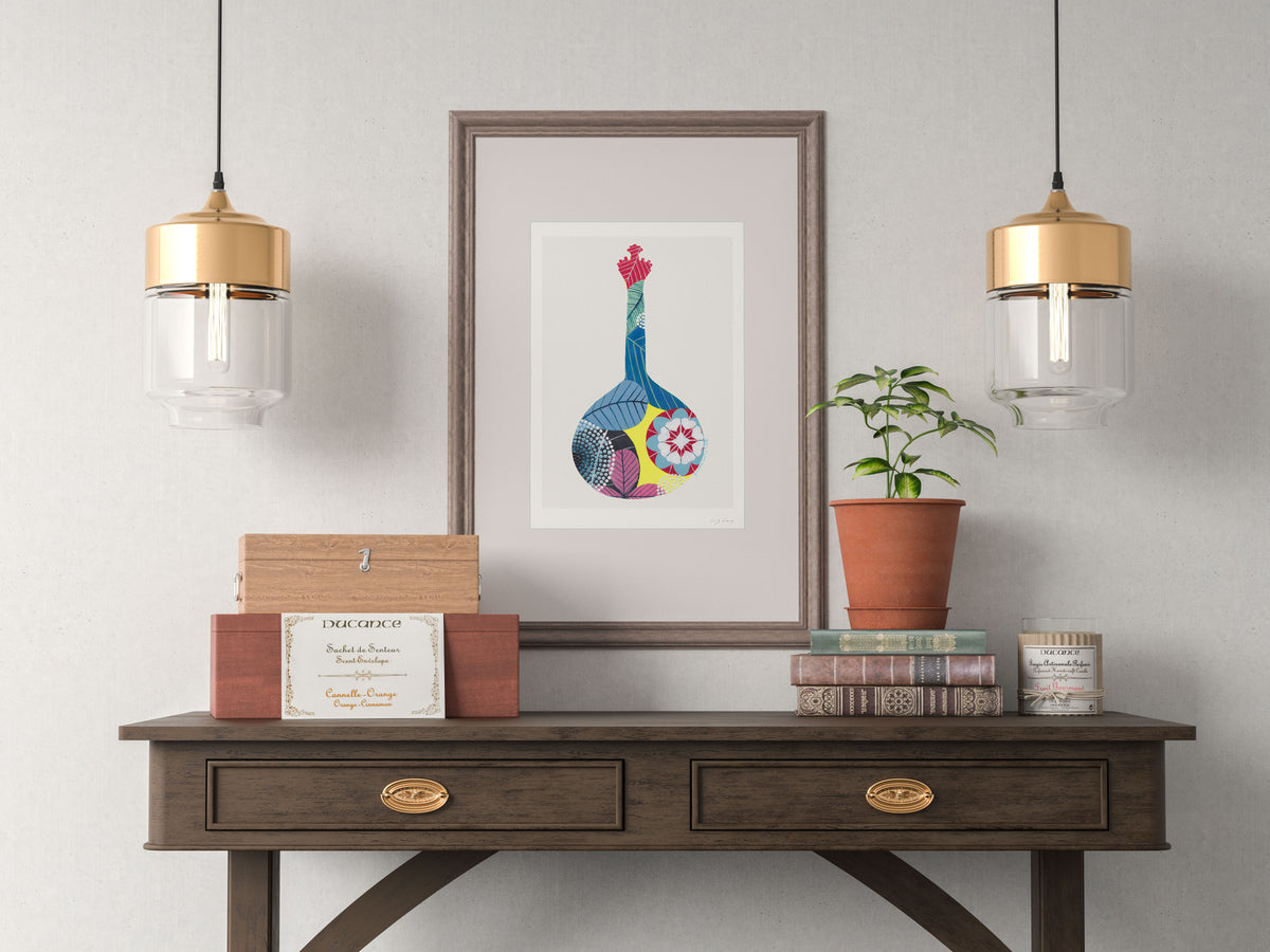 A framed fine art print, by Lis Gonçalves. Open edition, signed by the artist (printed in Hahnemühle matt fibre paper) featuring a colorful Portuguese guitar, on a wooden console table with decorative items against a gray wall