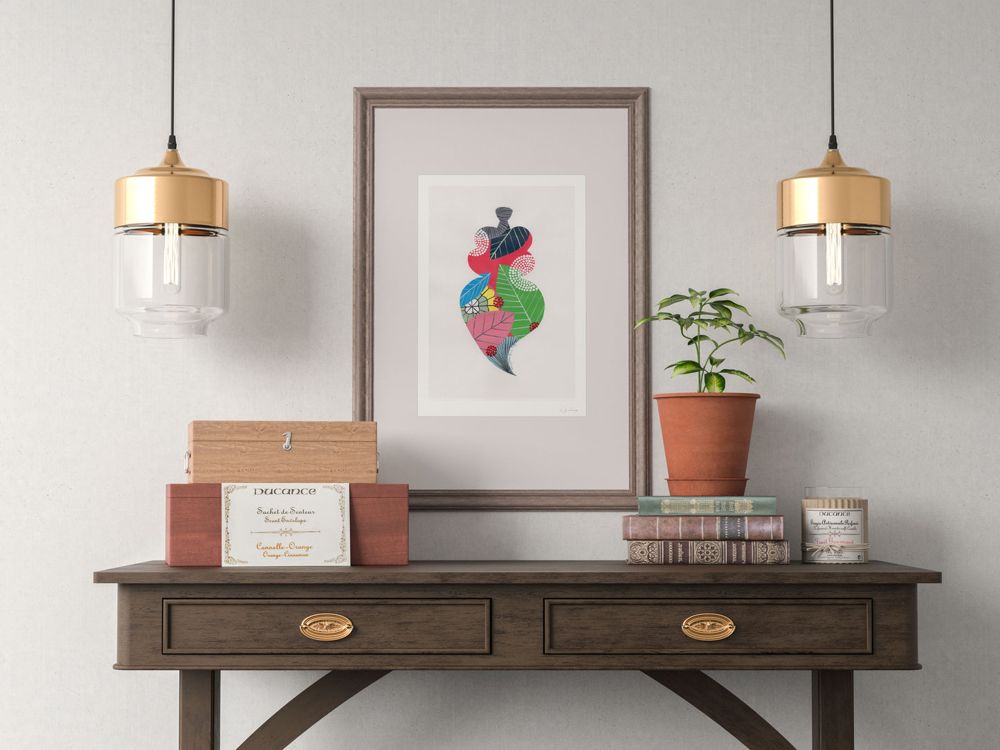A framed fine art print, by Lis Gonçalves. Open edition, signed by the artist (printed in Hahnemühle matt fibre paper) featuring a colorful Portuguese Viana heart in a decorative setup with a wooden console table and potted plant against a gray wall.