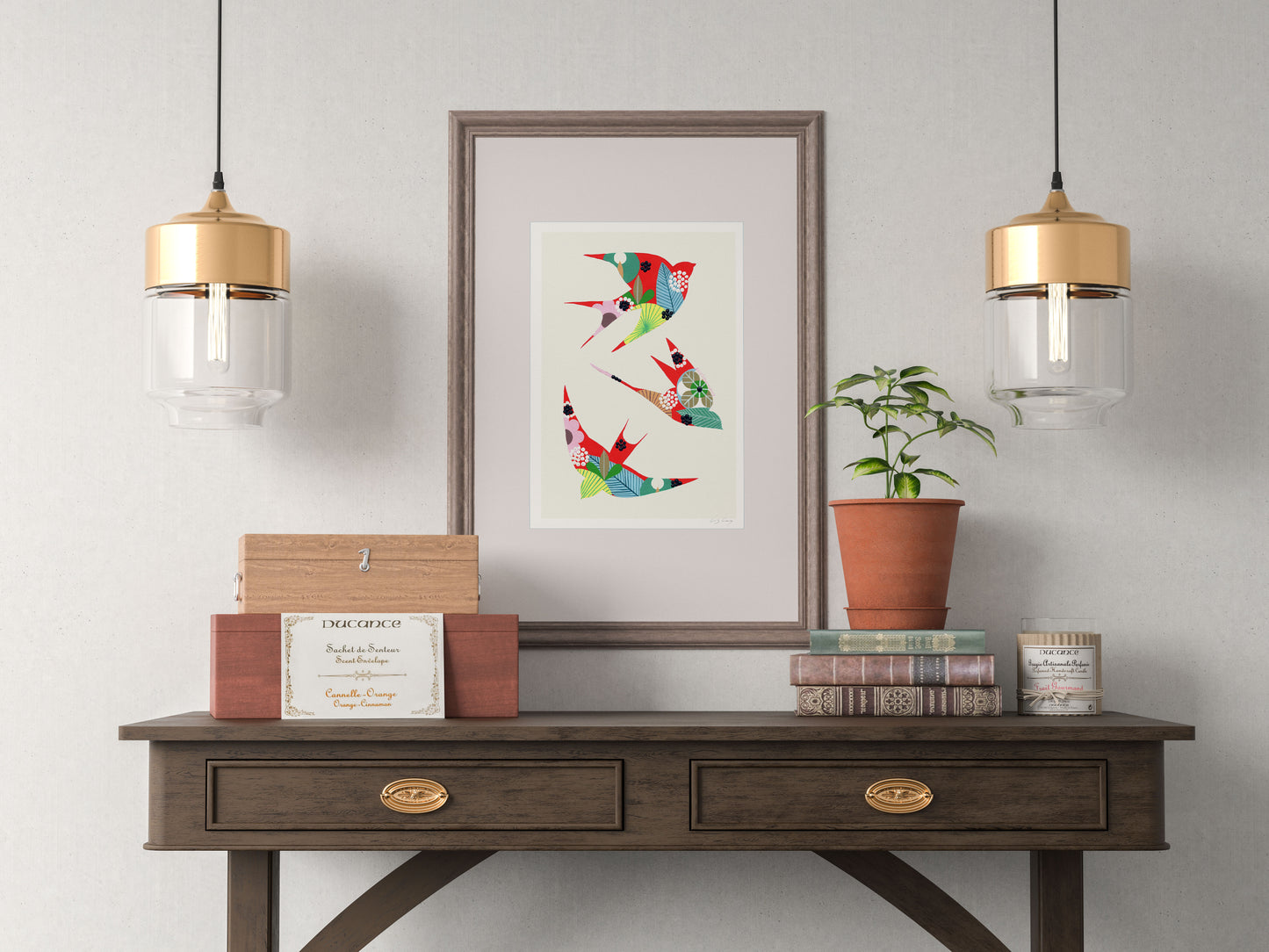 A framed fine art print, by Lis Gonçalves. Open edition, signed by the artist (printed in Hahnemühle matt fibre paper) featuring colorful swallows on a wooden console table with a potted plant, against a gray wall.