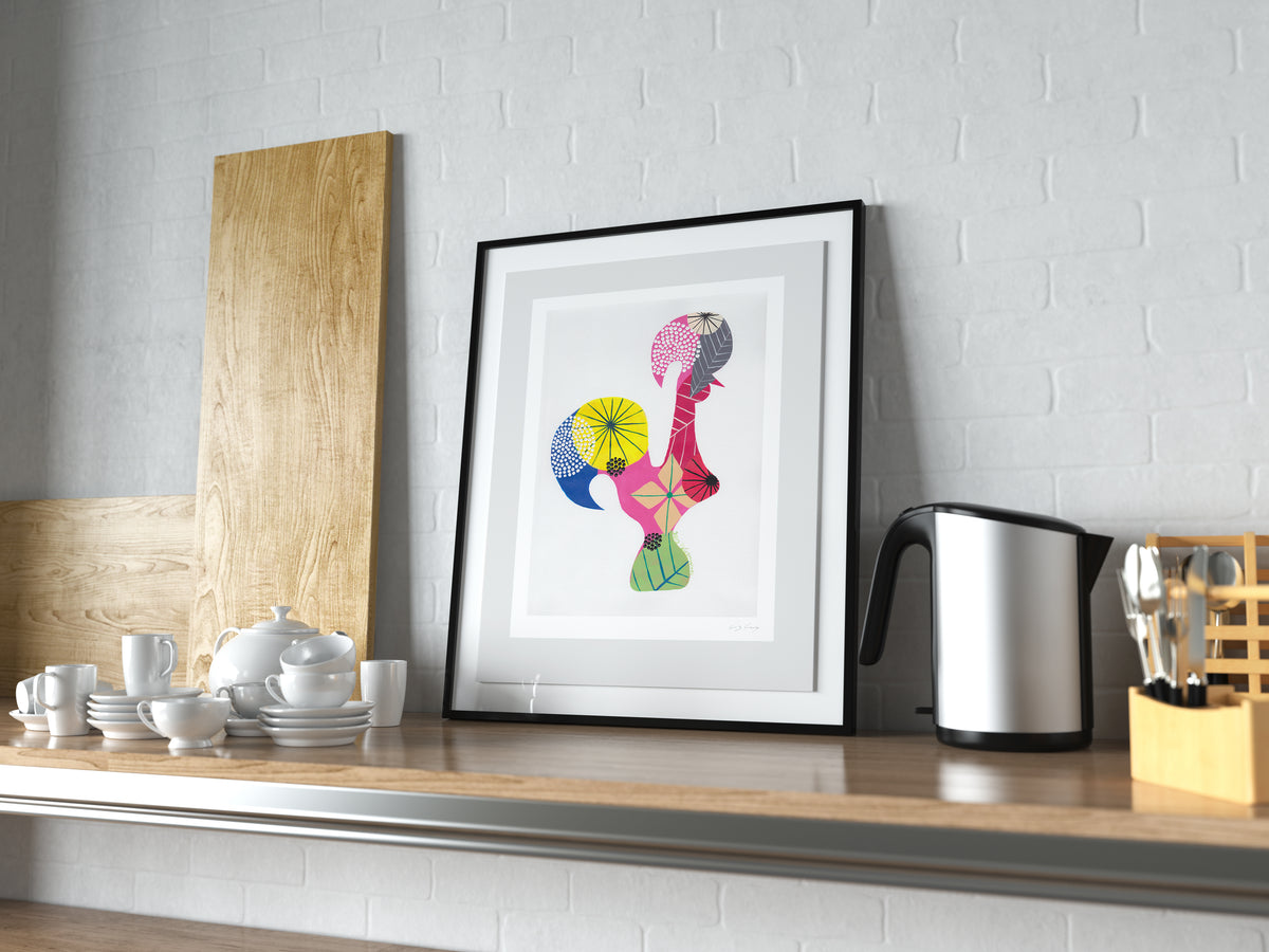 A framed fine art print, by Lis Gonçalves. Open edition, signed by the artist (printed in Hahnemühle matt fibre paper) featuring a colorful Portuguese rooster on a kitchen counter with utensils and appliances.